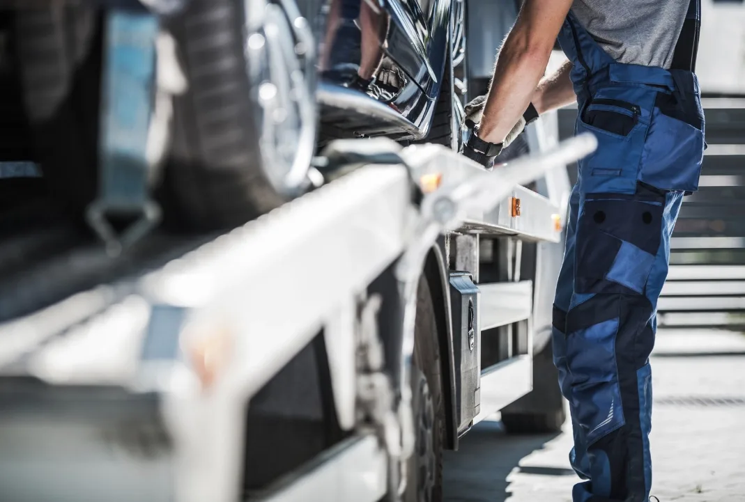 London tow truck driver loading a car onto a flatbed